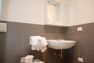 马格拉Hotel Lugano Torretta的浴室配有盥洗盆、镜子和毛巾
