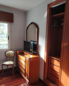 洛维奥斯Secondary home的客房设有带电视和镜子的梳妆台。