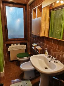 罗阿纳Elisa's Home的一间带水槽和卫生间的浴室以及窗户。
