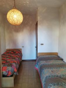 罗阿纳Elisa's Home的一间卧室配有两张床和吊灯。