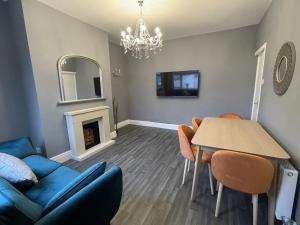 PembertonModa House Wigan - Beautiful 4 Bed Property的客厅配有蓝色的沙发和桌子