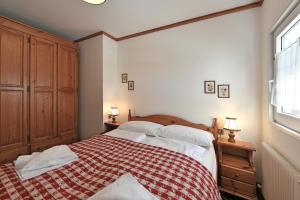 圣克里斯蒂娜Residence Hotel Casa Metz的一间卧室配有一张带红白毯子的床