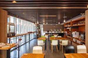 台北谦商旅 - 东门馆的配有木桌和白色椅子的餐厅