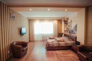 切尔尼戈夫莫乐科斯公寓式酒店的一间卧室配有一张床、一把椅子和电视