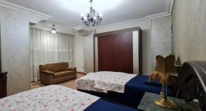 开罗Comfy 2-Bedrooms Apartment in Cairo 44-2的一间卧室配有两张床、一把椅子和一个吊灯。