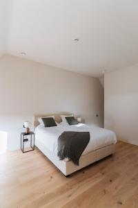 奥德纳尔德Duisbeke Logies的白色卧室设有一张大床和木地板