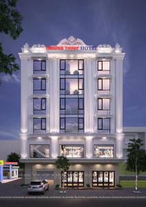 荣市Trường Thịnh Hotel的前面有停车位的建筑