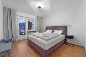 圣莫里茨Abitaziun Belmunt 103 - St Moritz "LOGA ELEGANCE APARTMENT"的一间卧室设有一张大床和一个窗户。