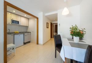 帕格拉Apartamentos Los Tilos的厨房以及带桌椅的用餐室。