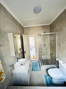 SandtonAt Home的浴室配有卫生间、盥洗盆和淋浴。