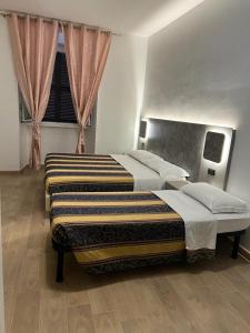 罗马Hotel principe的一间卧室设有两张床和窗户。