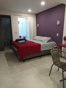 里约热内卢Suítes/Studios Privados Copacabana的一间卧室配有一张床和紫色的墙壁
