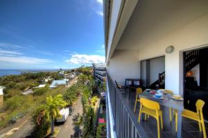 FleurimontL'appartement de l'Horizon - Plateau Cailloux的一个带桌椅的海景阳台