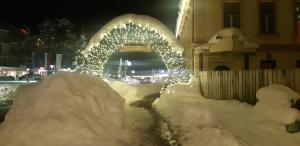 克拉尼斯卡戈拉Sunny place的一座有灯光的拱门被雪覆盖的建筑