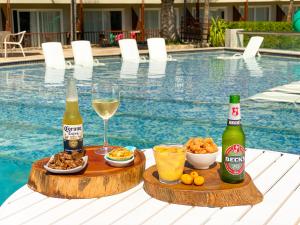 马塞约Salinas Maceio All Inclusive Resort的一张桌子,上面放有两瓶啤酒、食物和饮料