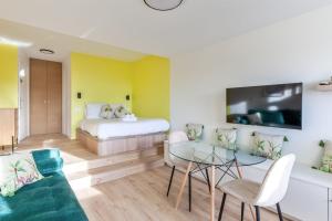多维尔Brand new studio with sea view in the Deauville port - Welkeys的客房设有床、沙发和桌子。