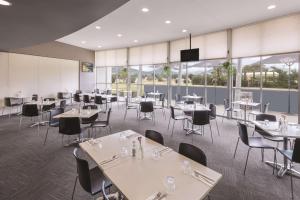 剑桥霍巴特机场旅程住宿酒店的用餐室设有桌椅和窗户。