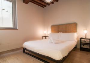 佩鲁贾Umbrian Concierge - La Corte del Grillo的一间卧室配有一张带两盏灯的大型白色床。