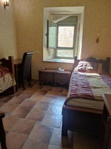 阿卡埃克泰尔精品酒店的一间卧室设有一张床、一个窗口和一张桌子