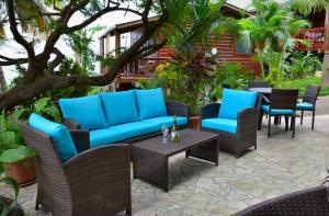 西湾西湾别墅&Spa的庭院设有藤椅、蓝色沙发和桌子。