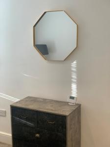 奥萨格Alsager Town Centre Apartment的梳妆台上方墙上的镜子,带抽屉
