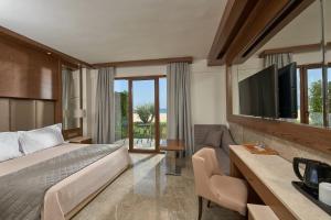 帕拉利亚卡泰里尼斯Mediterranean Village Hotel & Spa的酒店客房,配有床和电视