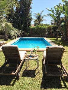 米哈斯科斯塔Las Gitanillas, villa with heated pool, La Cala de Mijas的游泳池畔的两把椅子和一张桌子