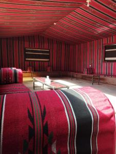 瓦迪拉姆Sunset Mountain的红色的房间,配有床和桌子