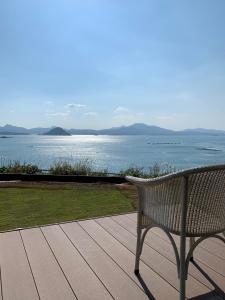 上天草Kamiamakusa - House - Vacation STAY 54914v的坐在甲板上的长凳,眺望着水面