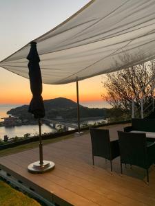 上天草Kamiamakusa - House - Vacation STAY 54914v的甲板上白色遮阳伞下的桌椅
