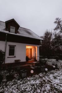 佐洛恰尼Csendes, modern, otthonos társasházi lakás的一座白色的小房子,地面上积雪