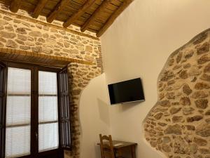 Benalúa de GuadixEl Carmen的一间客厅,在石墙上配有电视