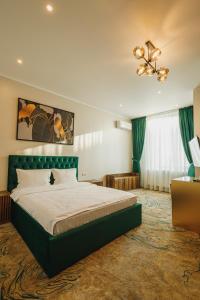 TecuciMotel Andra的一间卧室配有一张大床和绿色床头板