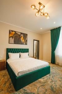 TecuciMotel Andra的一间卧室配有一张大床和绿色床头板