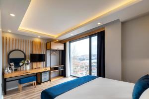 伊斯坦布尔Union Hotel Karaköy的一间卧室配有一张床和一张书桌及电视