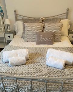惠特比Seaspray Boutique Whitby Apartment的床上有两条毛巾和爱枕头