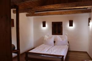CaraşovaSalaš u Bregu in Cheile Carasului的一间卧室配有带白色床单和枕头的床。
