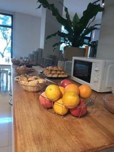 马德普拉塔Alsina Suites的一张桌子,上面放着水果篮和微波炉