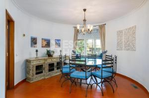 阿玛考德佩拉Quinta do Vale Formoso的一间设有玻璃桌和蓝色椅子的用餐室