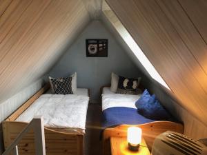 普鲁滕romantisches Ferienhaus Boddenblick mit Sauna的阁楼上的卧室配有两张床