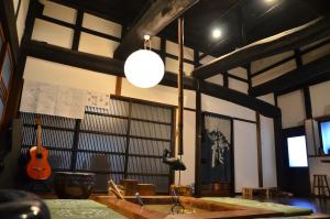 Ayabe一汁一菜の宿　ちゃぶダイニング Ichiju Issai no Yado Chabu Dining Unforgettable Farmstay experience in Deep Kyoto的一间设有吉他、水槽和灯的房间
