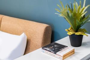 台北Lin Suites by Olala Homes的书和床边桌子上的植物