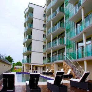 MutumbaParadise Appartment hotel的一座带椅子和游泳池的大型公寓大楼