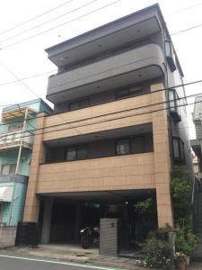 东京Oku Apartment的停在前面的一座带摩托车的建筑