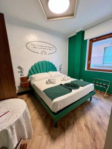 圣马力诺Rainbow Hotel Depandance Joli的一间卧室配有一张带绿色床头板的床