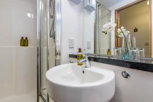 爱丁堡KM Apartments的白色的浴室设有水槽和淋浴。