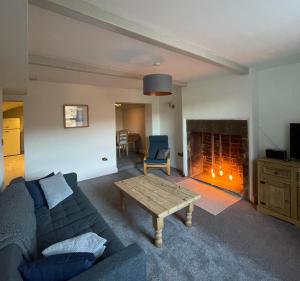 霍姆弗斯Brook Cottage的带沙发和壁炉的客厅