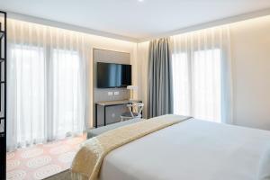格拉纳达Boutique Hotel Luna Granada Centro的配有一张床和一台平面电视的酒店客房