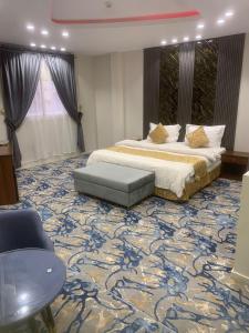 图赖夫Orchida Turaif Hotel 1的一间卧室配有一张大床和一张大地毯