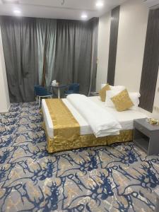 图赖夫Orchida Turaif Hotel 1的一间卧室配有一张床和两张蓝色椅子